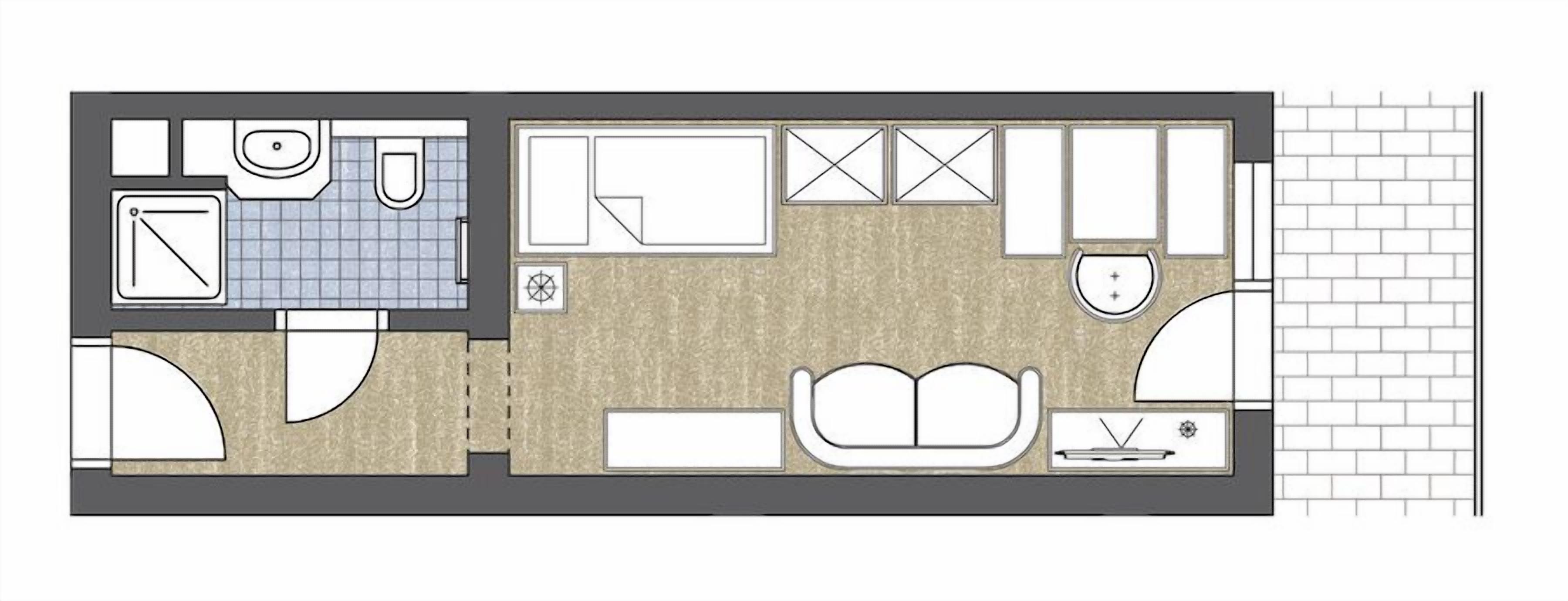 A floor plan of a hotel room with a bathroom, a kitchenette, a seating area with a sofa and armchairs, and a small table.