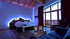 A room with a bed, a TV, a glass coffee table, and a sofa. - Seelos (Seefeld in Tirol)