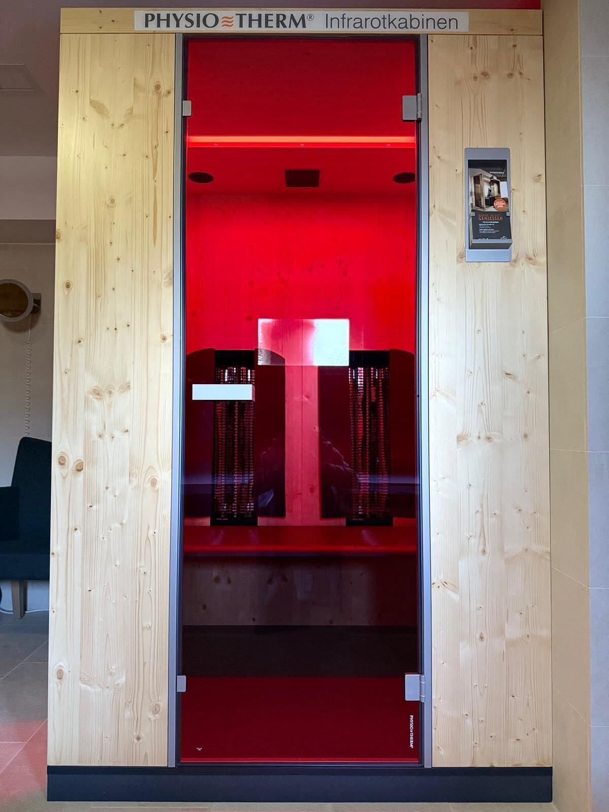 A red-framed cabinet with the label 'PHYSIO THERM Infrarotkabinen' indicating a sauna room.