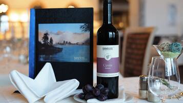 A bottle of Seelos wine, a plate with grapes, and a decorative item on a table.
