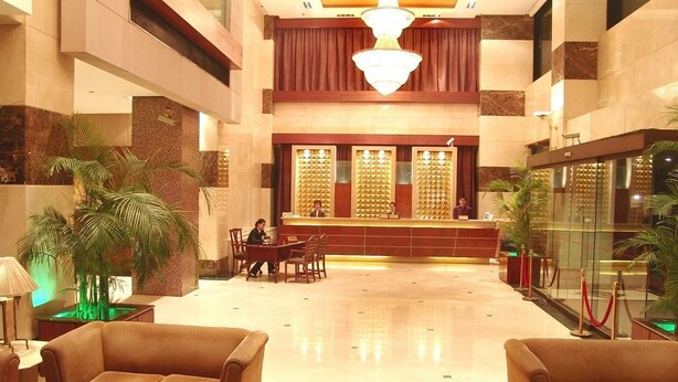 A lobby with a reception desk, seating area, and decorative plants. - Shanghai Changhang Hotel (Shanghai)