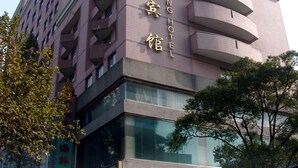 A multi-story hotel with a prominent clock tower and a sign indicating it is the Shang Hotel. - Shanghai Changhang Hotel (Shanghai)