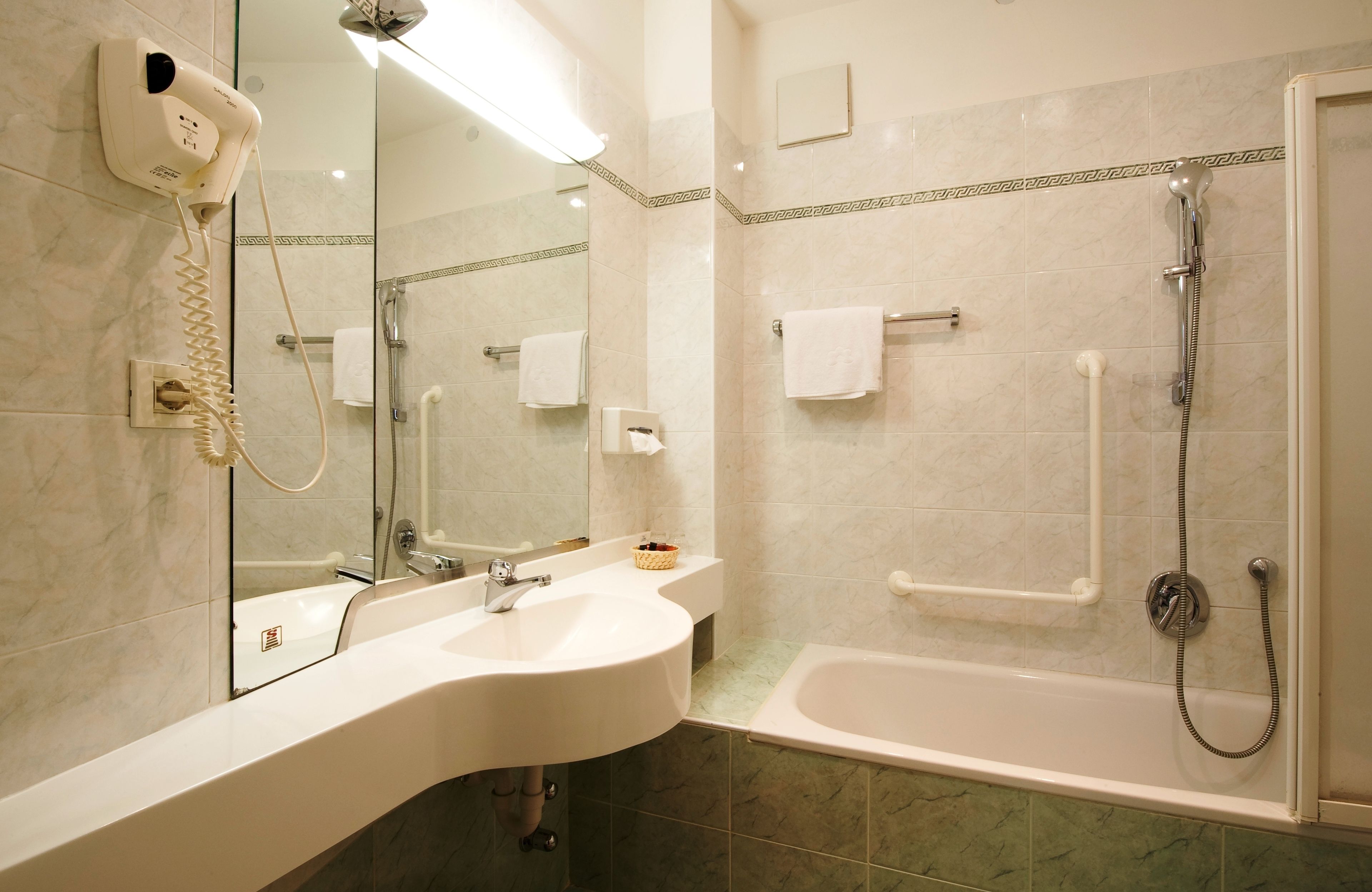 A modern bathroom with a sink, mirror, and a walk-in shower.