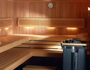 Una sauna con bancos de madera y un panel de control.