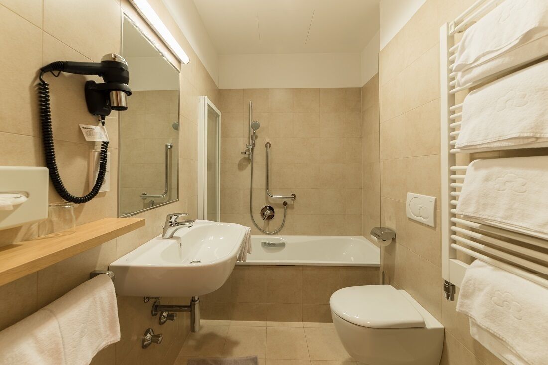 Et moderne badeværelse med vask, toilet og brusebad.