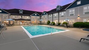 A hotel with a swimming pool, outdoor seating, and a sunset sky. - The Hotel Saratoga, an Ascend Collection Hotel (Saratoga Springs)