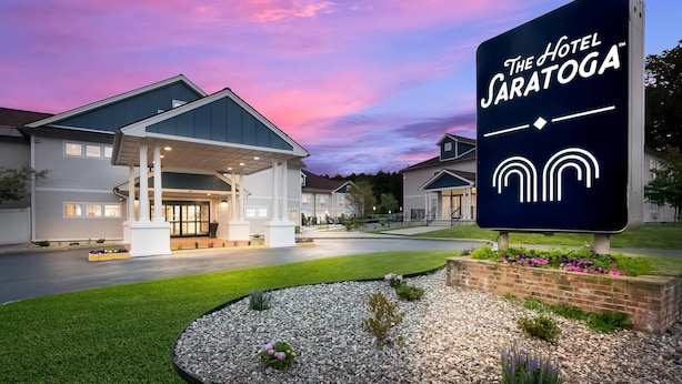 A hotel with a covered entrance, landscaped garden, and a sign reading "The Hotel Saratoga." - The Hotel Saratoga, an Ascend Collection Hotel (Saratoga Springs)
