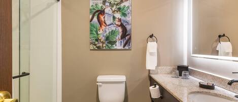 Un baño con inodoro, lavamanos, espejo y ducha.