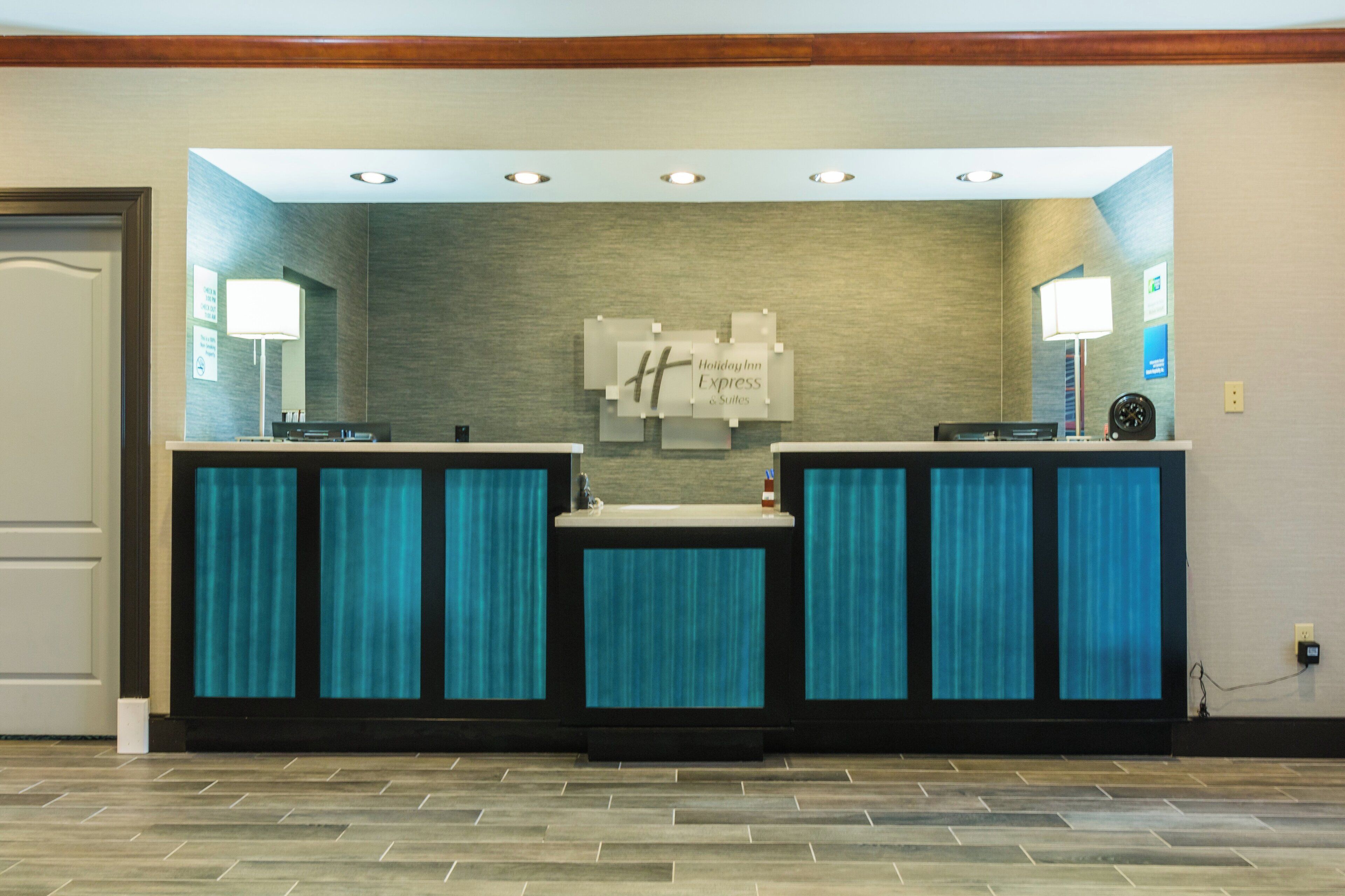A reception area with a reception desk, a wall-mounted sign, and a door.
