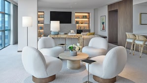 A modern living room with a sofa set, a coffee table, and a dining area with chairs.