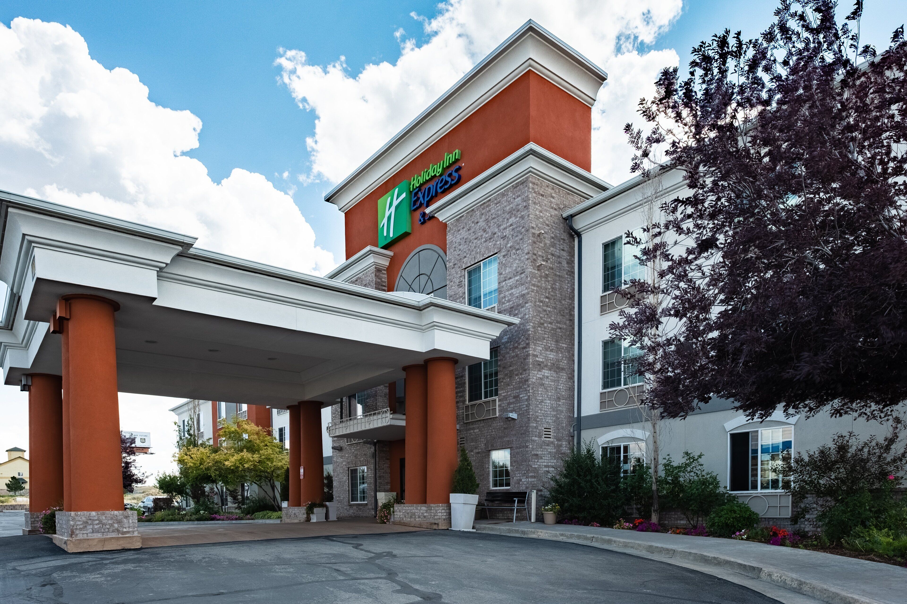 A Holiday Inn Express building with a brick facade, large columns, and a covered entrance area.