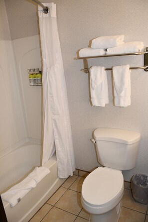 A bathroom with a bathtub, toilet, and towel rack.