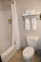 Un baño con bañera, inodoro y barra para toallas.