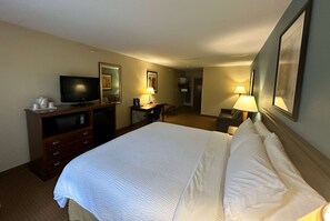 A hotel room with a bed, a television, a desk, and a chair.