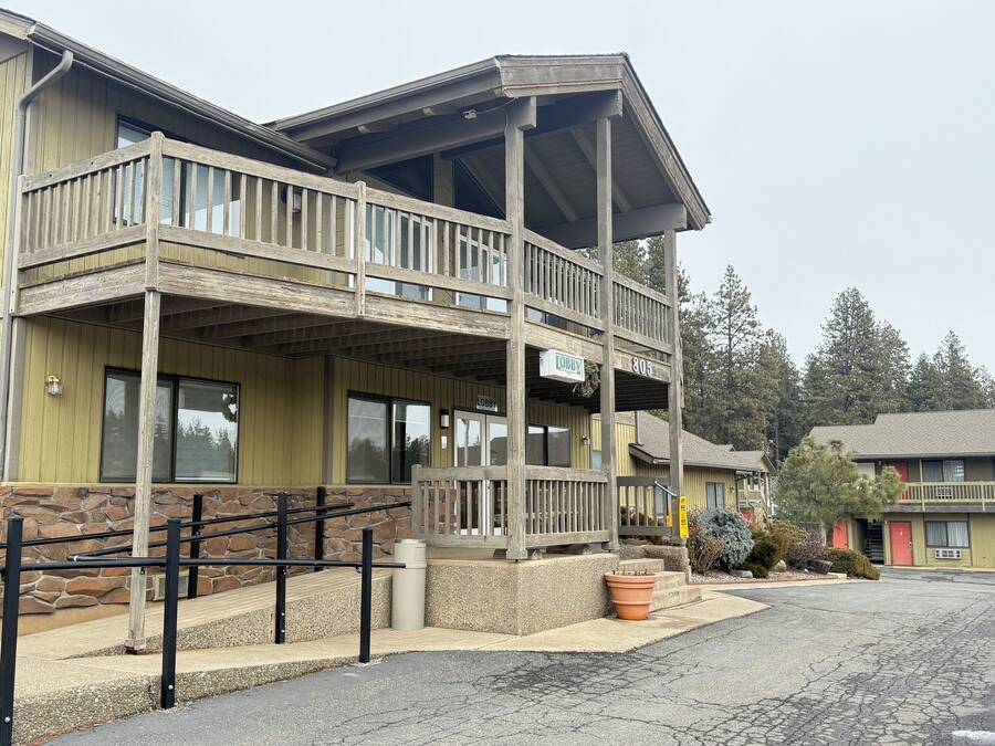 A two-story building with a wooden balcony and a stone facade.