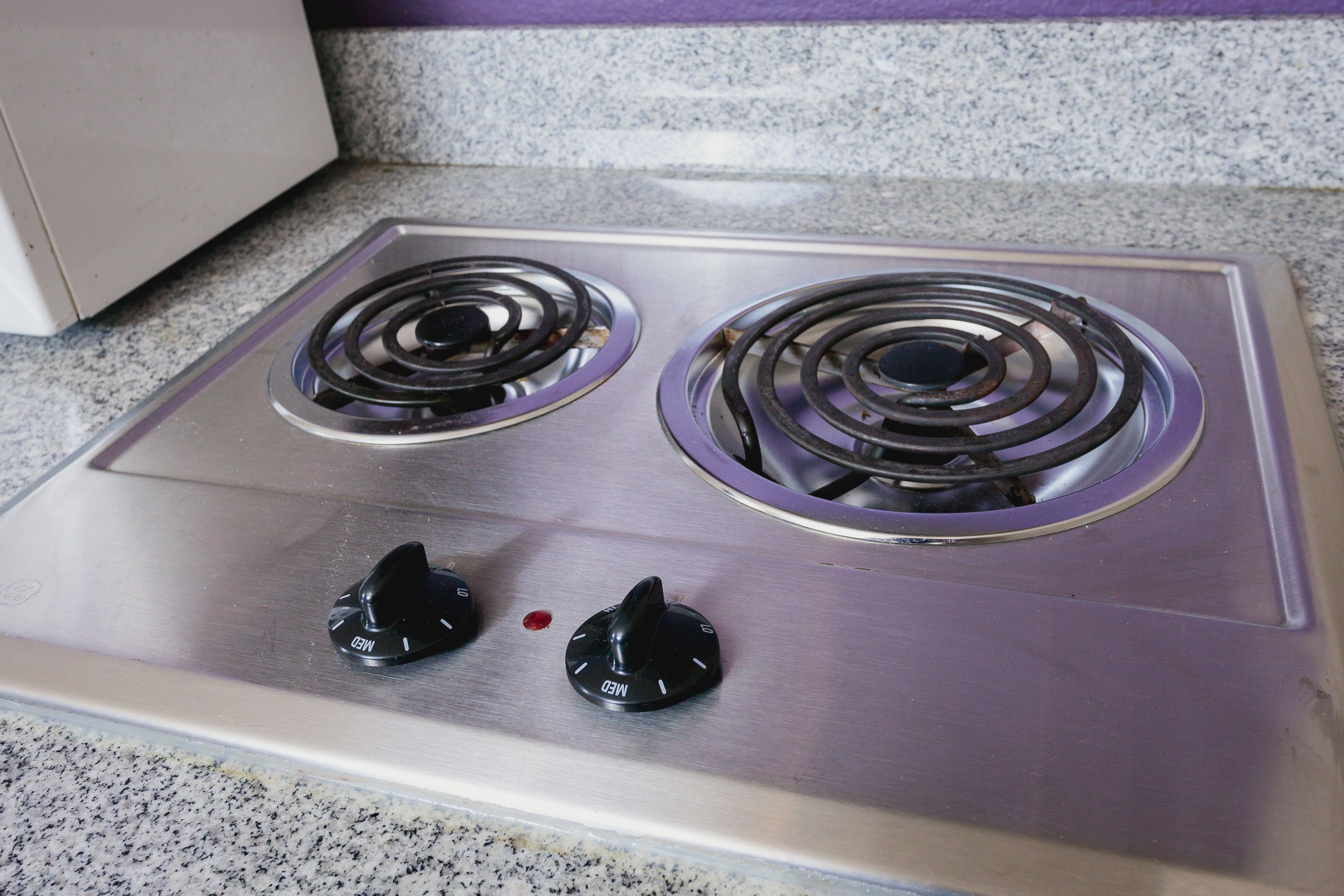 A stainless steel stove with two burners and two knobs.