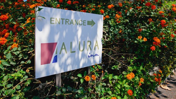 Un panneau indiquant l’entrée d’un hôtel appelé « ALURA inn ».