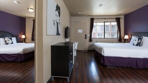 Une chambre d’hôtel avec deux lits, un bureau et une fenêtre avec des rideaux.