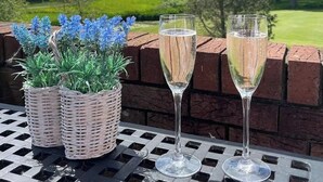 Una mesa con dos copas de champán y una cesta de flores azules.