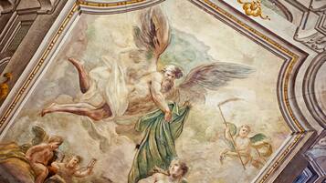 A detailed fresco mural on a ceiling, featuring mythological figures and classical architecture.
