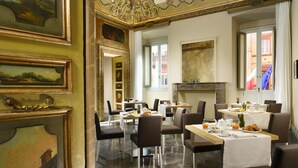 A dining area with tables set for breakfast, featuring breakfast items and a fireplace. - Locanda della Posta - Etruria Collection (Perugia)
