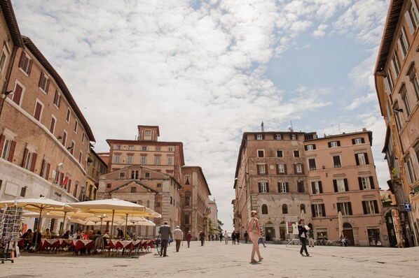 A square with outdoor seating, surrounded by historic buildings with uniform architecture.