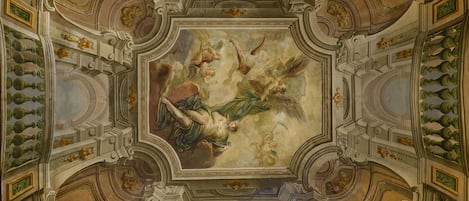 A ceiling with elaborate frescoes and architectural details.