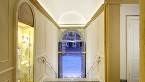 A hallway with a checkered floor, a glass display case, and a staircase leading to an outdoor area. - Locanda della Posta - Etruria Collection (Perugia)