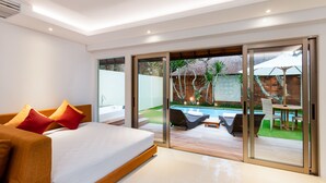 Un dormitorio moderno con una cama grande, puertas de vidrio correderas que dan a un espacio exterior con piscina y mobiliario.