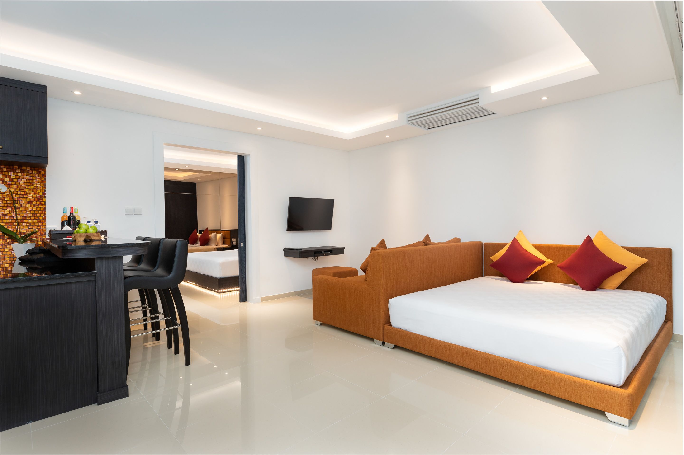 Ein modernes Hotelzimmer mit einem großen Bett, einem Schreibtisch und einem Fernseher.