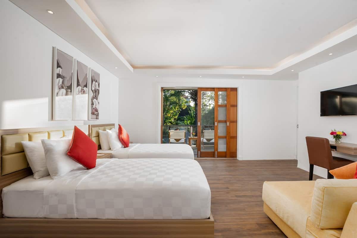 A modern hotel room with two beds, a sofa, a TV, and a balcony with outdoor furniture.