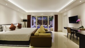 Una habitación de hotel moderna con una cama grande, un sofá, un escritorio y un televisor.