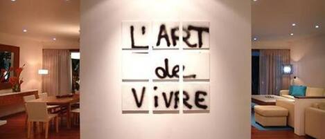 Un saló modern amb una obra d'art penjada a la pared que mostra la frase "L'ART de Vivre".