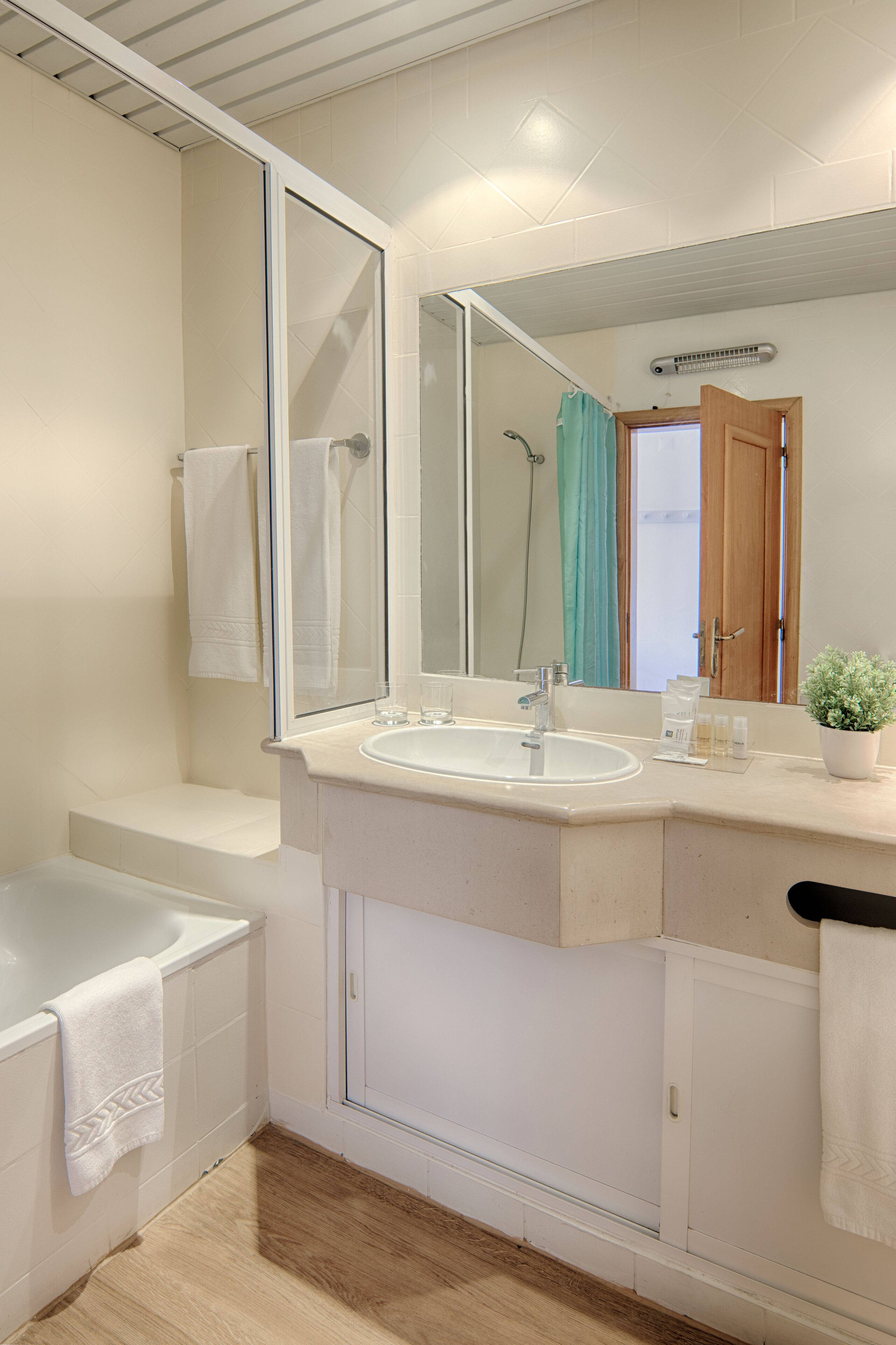 A modern bathroom with a bathtub, a sink, and a large mirror.