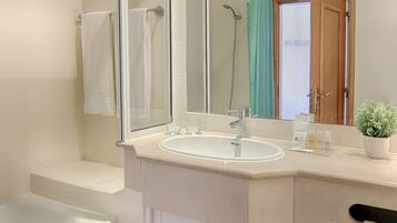 A modern bathroom with a bathtub, a sink, and a large mirror.