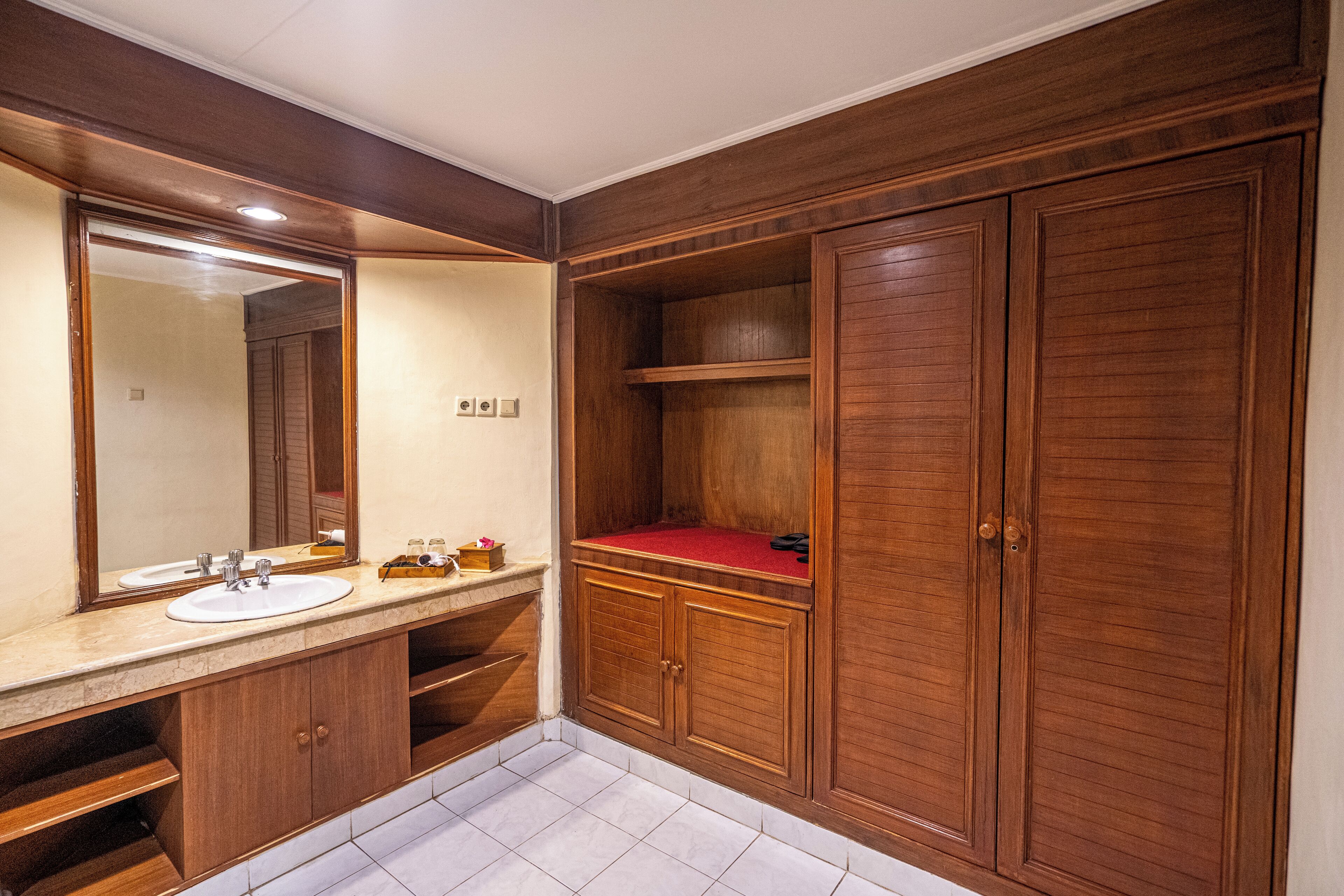 A bathroom with wooden cabinets, a sink, and a mirror.