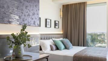 Una habitación de hotel moderna con una cama, un florero con una planta, cuadros en la pared y vistas a la ciudad.