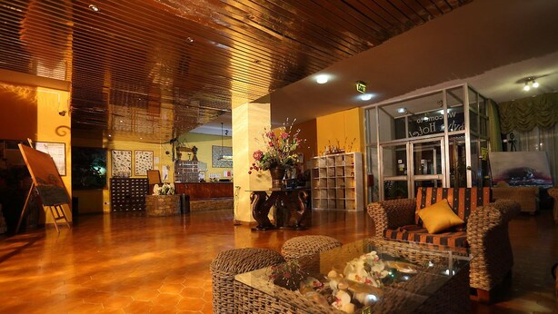 A spacious lobby with a wooden ceiling, wicker furniture, and a glass coffee table. - Sylva Hotel (Limassol)