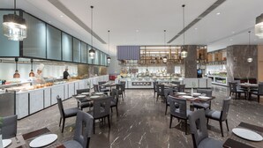 Ein modernes Restaurant mit einer zentralen Bar, mehreren Essplätzen und einem Marmorboden.