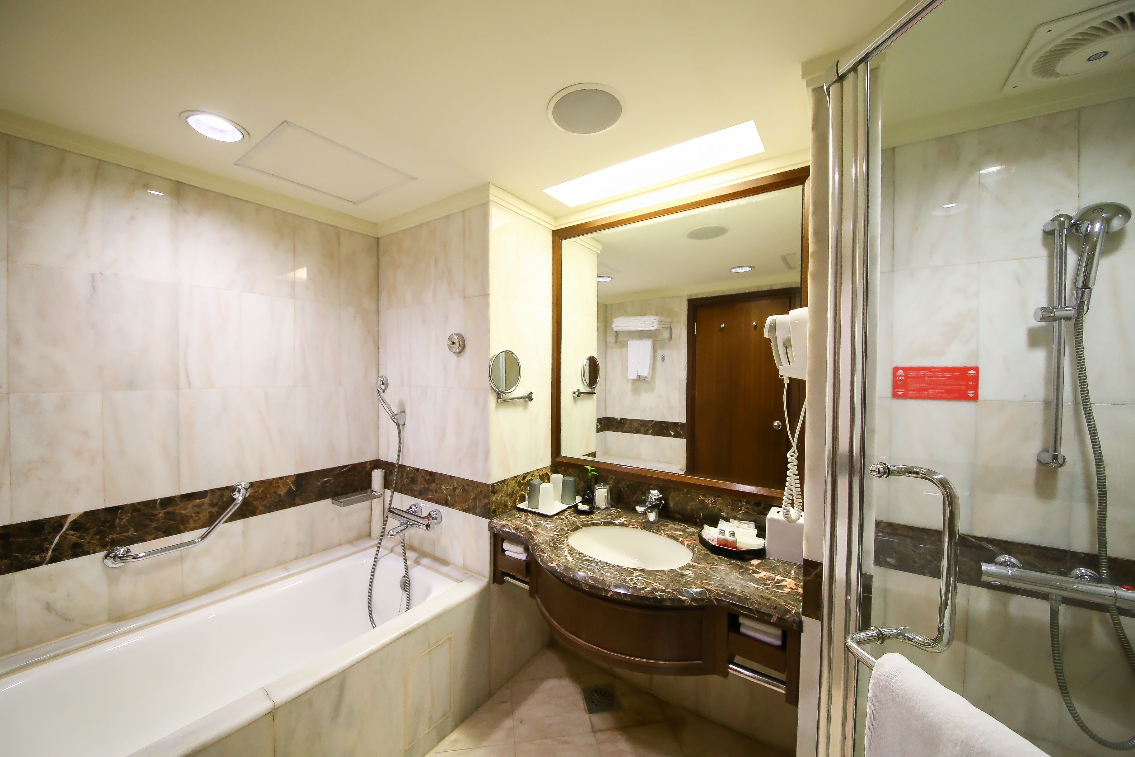A modern bathroom with a bathtub, a sink, and a shower area.