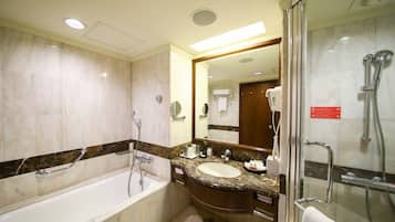 A modern bathroom with a bathtub, a sink, and a shower area.