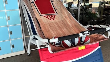 A sports training area with a netted floor, a red mat, and a blue and red sports bag labeled "MD SPORTS".