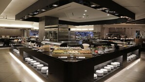 Montaje moderno de bufé con diversas opciones de comida y una zona central de servicio.