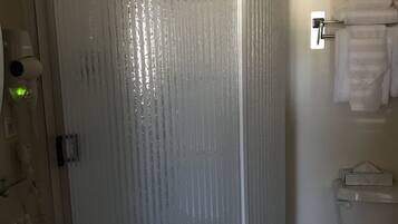 A bathroom with a shower enclosure, a sink, and a toilet.