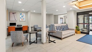A modern lounge area with seating, a sofa, and a coffee station.