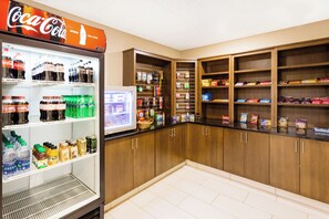 A vending machine stocked with beverages and snacks, with a Coca-Cola sign above it. - Holiday Inn Express Princeton by IHG (Princeton)