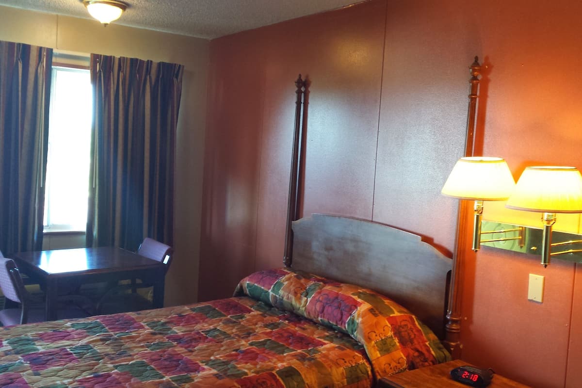 Ein Hotelzimmer mit einem Bett, einem Schreibtisch und zwei Lampen.