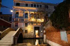 A historic building with a grand entrance, a staircase leading to a balcony, and a canal in front. - Ca' Vendramin Zago (Venice)