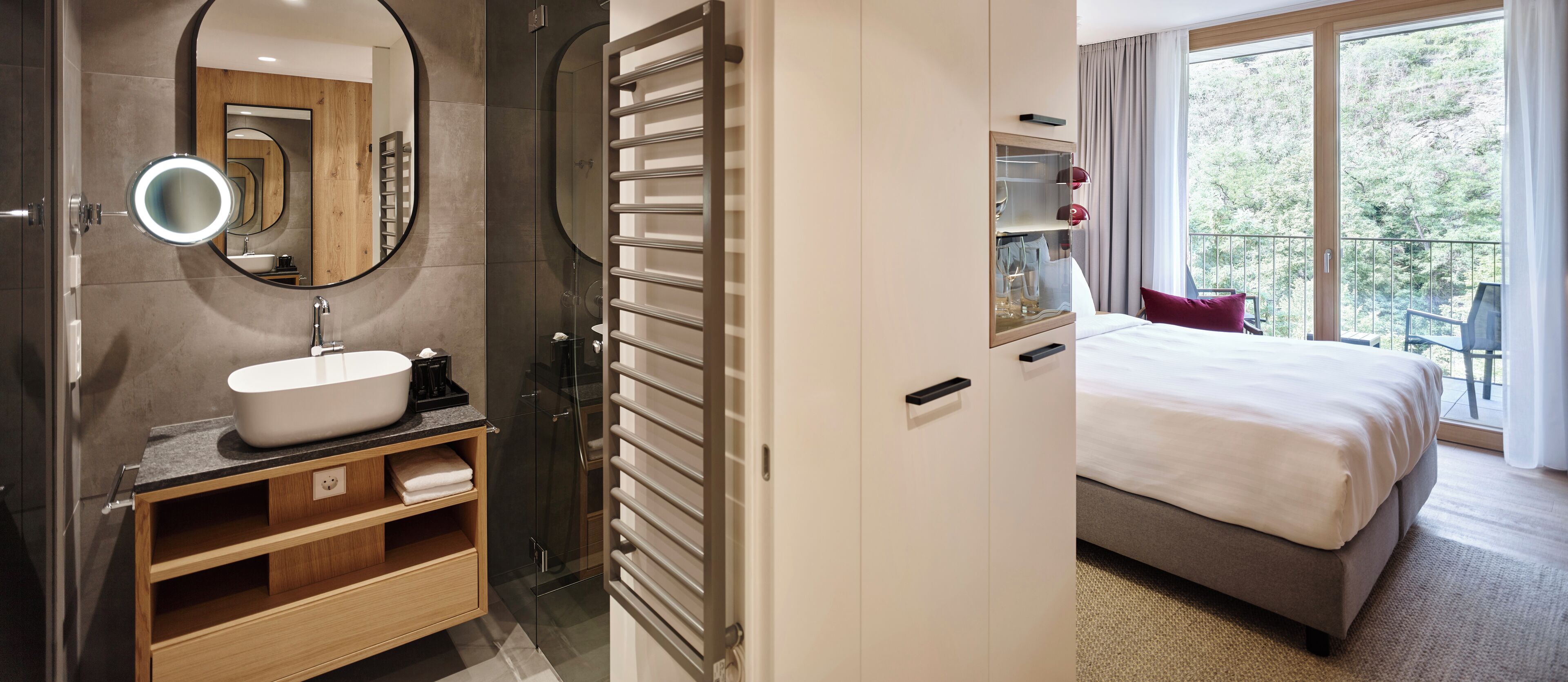 A modern bathroom with a large mirror, a sink, and a glass shower enclosure.