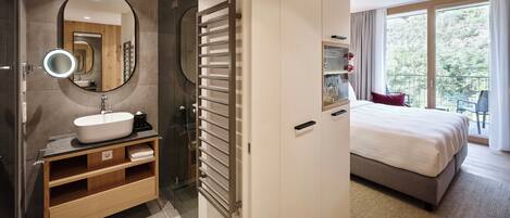 A modern bathroom with a large mirror, a sink, and a glass shower enclosure.